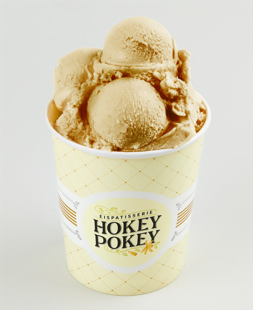 Becher mit cremigem Lakritzeis der Eispatisserie Hokey Pokey Berlin, serviert im gelben Markenbecher vor hellem Hintergrund – intensiv, würzig und handgemacht.