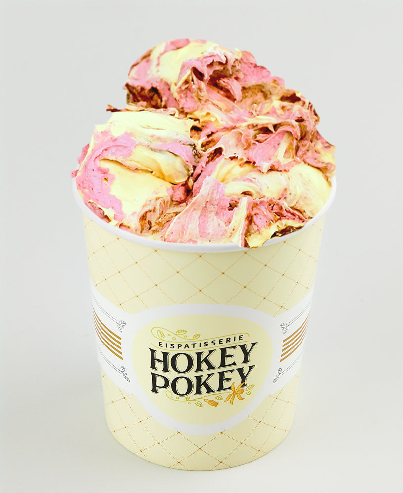 Becher mit Pflaume-Butterkaramell-Eis der Eispatisserie Hokey Pokey Berlin, kunstvoll marmoriert in Rosa und Creme, serviert im gelben Markenbecher vor hellem Hintergrund.