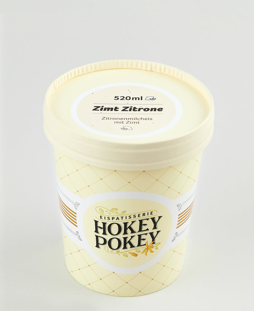 Becher mit 520 ml „Zimt Zitrone“-Eis von Hokey Pokey – Zitronenmilcheis mit Zimt in cremigem Hellgelb, stilvoll verpackt in einem pastellfarbenen Eisbecher.