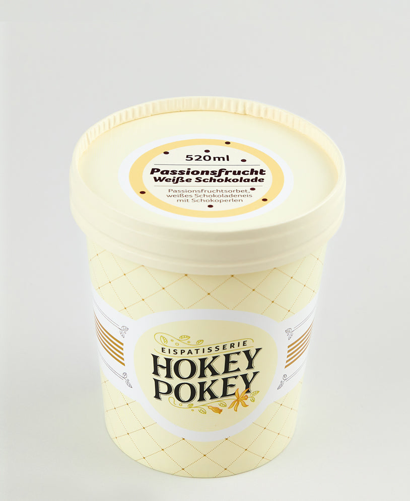 520 ml Becher der Eispatisserie Hokey Pokey – Sorte Passionsfrucht Weiße Schokolade mit Sorbet, weißem Schokoladeneis und Schokoperlen, in cremefarbenem Design mit Logo.
